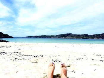 Low section of woman relaxing on beach