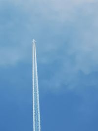 Low angle view of airplane flying against sky