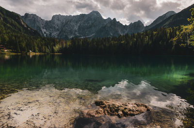 Scenic view of lake and mountains against cloudy sky