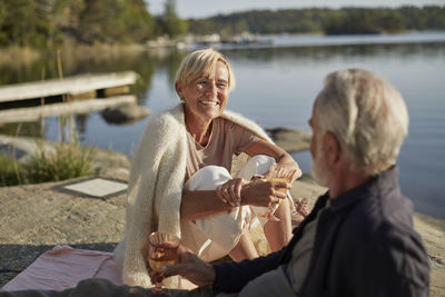 Smiling couple having picnic at lake