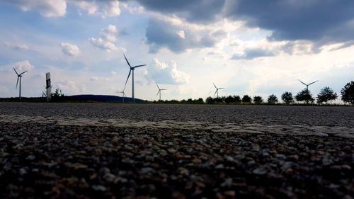 Wind turbines on land against sky