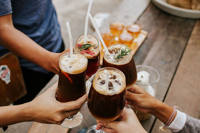 High angle view of people holding glass of table