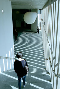 Rear view of woman walking on staircase in building