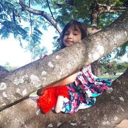 Portrait of cute girl smiling by tree