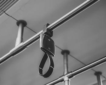 Low angle view of clothespins hanging on railing against sky