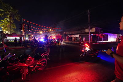 People on illuminated street at night