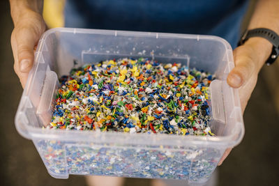 Man holding recycled plastic in container