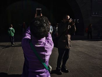 Full length of woman standing on footpath