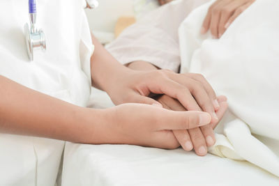 Midsection of woman lying on bed