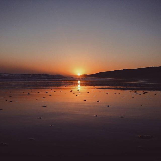 sunset, water, tranquil scene, scenics, tranquility, sun, sea, beauty in nature, reflection, clear sky, beach, orange color, silhouette, idyllic, copy space, nature, shore, horizon over water, sky, sunlight