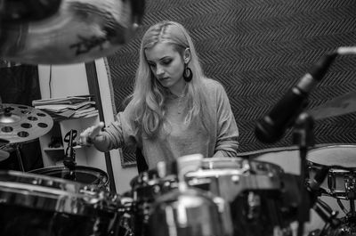 Close-up of young woman playing drums