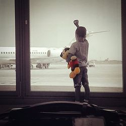 Boy looking through airplane window