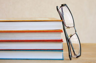 Eyeglasses with stack of book on table
