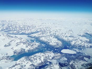 Scenic view of snowcapped landscape against blue sky