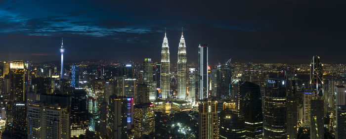 Illuminated cityscape against sky at night