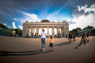 People walking against built structure