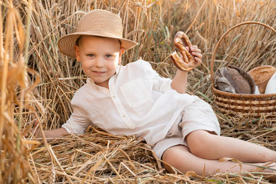 Portrait of cute baby girl with hat on hay