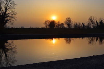 Scenic view of lake against orange sky