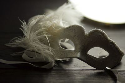 Close-up of eye mask with feather on table