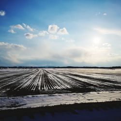 Scenic view of snow covered land against sky