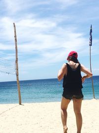 Full length of woman walking at beach against sky