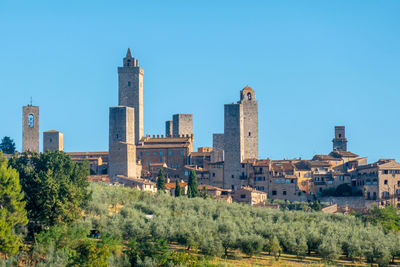 Buildings in city against blue sky