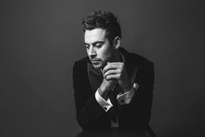 Portrait of young man against black background