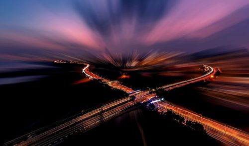 Light trails on road against sky at night