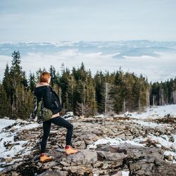 Rear view of woman  hiking in forest against sky