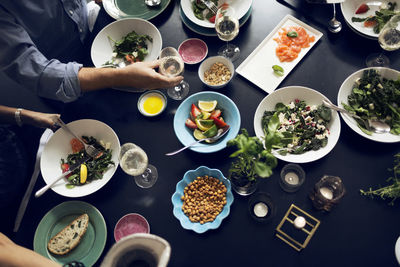 Cropped image of friends eating food at table