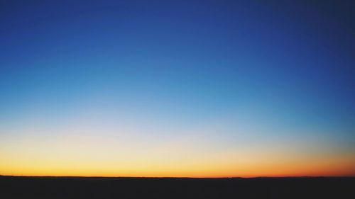 Silhouette of landscape against clear sky at sunset