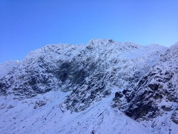 Scenic view of snow covered mountains against clear sky