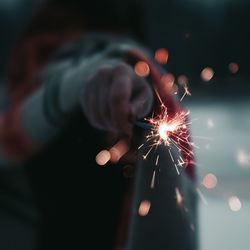 Close-up of hand holding sparkler at night