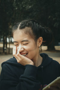 Portrait of smiling young woman looking away outdoors