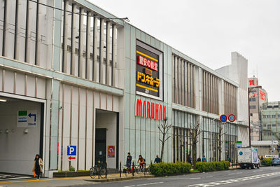 Group of people walking on road against buildings