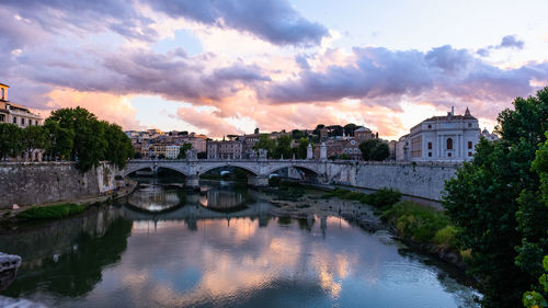 Bridge over river against sky during sunset