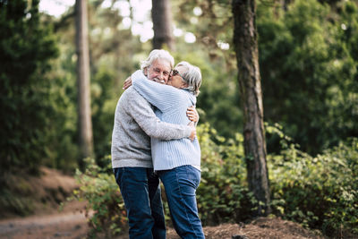 Senior couple embracing and kissing at forest