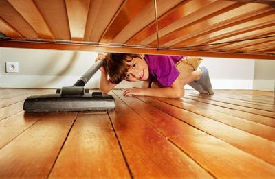 Full length of woman sitting on hardwood floor