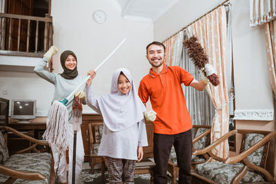 Happy family cleaning house at home