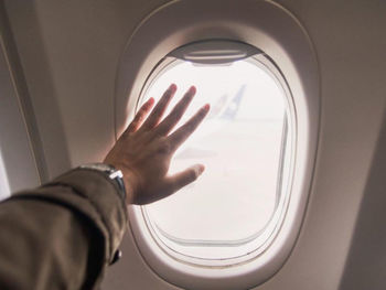 Midsection of man seen through airplane window