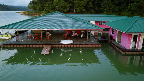 View of swimming pool by lake against buildings