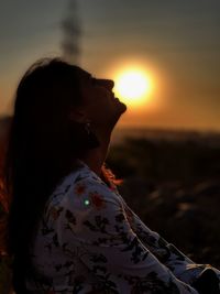 Midsection of woman against sky during sunset