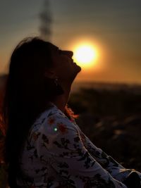 Side view of silhouette woman against sky during sunset