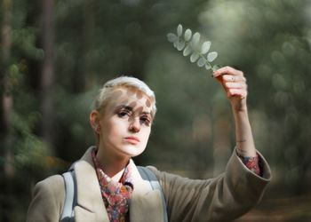 Portrait of woman holding camera in park