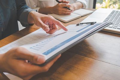 Cropped image of business colleagues working at desk in office