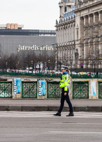 Full length rear view of man walking on street against buildings