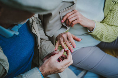 Midsection of couple holding hands