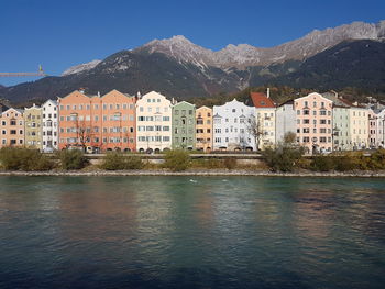 Houses in town by mountains against clear sky