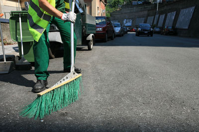 Low section of man working on street in city