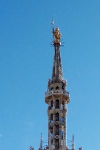 Low angle view of statue of building against blue sky